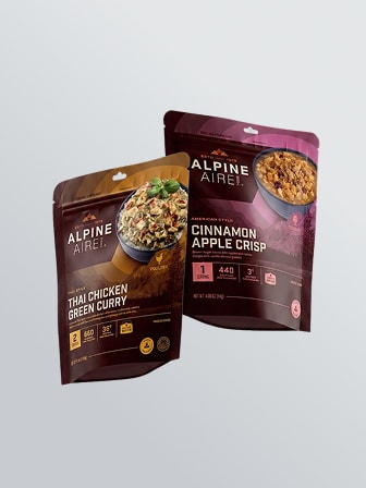 Trek 'n Eat freeze-dried meal pouch being prepared with hot water in an outdoor setting