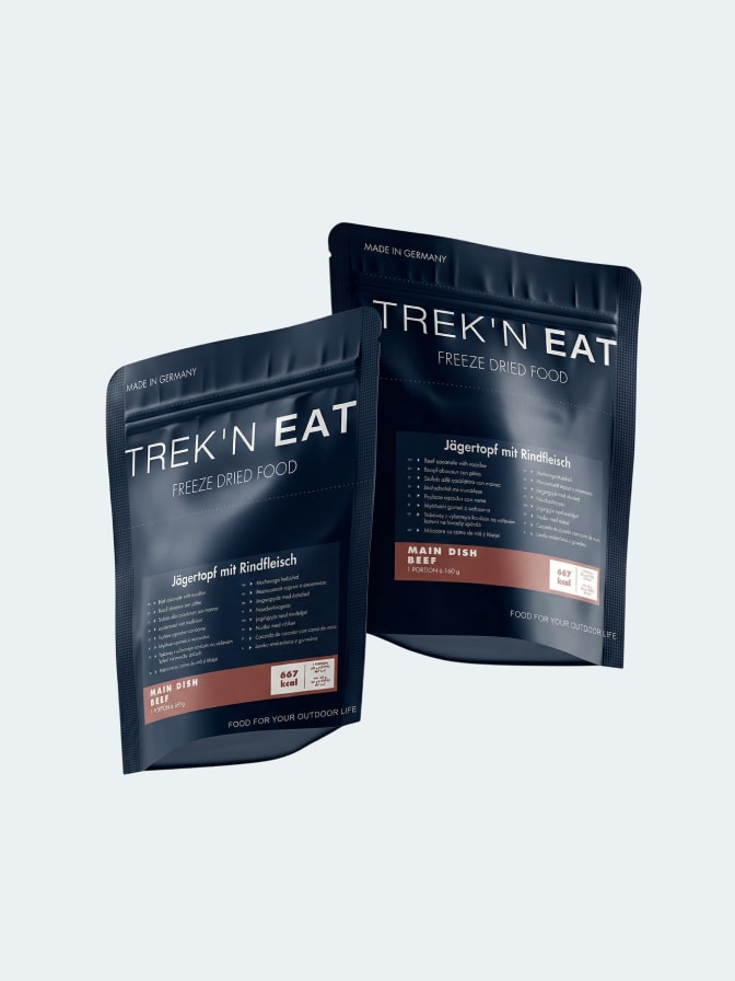 Trek 'n Eat freeze-dried meal pouch being prepared with hot water in an outdoor setting